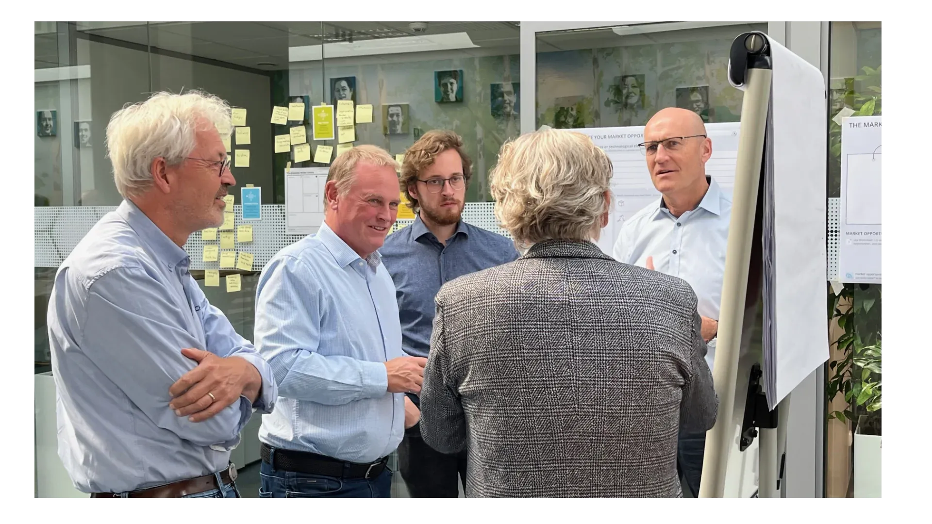 A management team around a scorecard on the wall